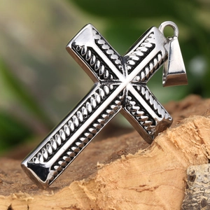 Polished stainless steel cross pendant with rope texture inlay on rustic bark background