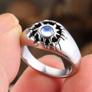 Macro detail of retro silver ring with sunburst totem and blue gemstone inlay