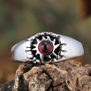 Vintage punk silver ring with red stone setting on natural wood background display