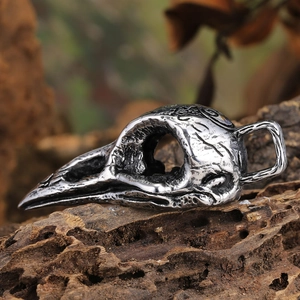 Vintage gothic raven skull pendant with bone totem engravings on weathered wood