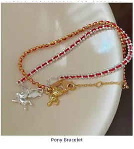 Dettaglio macro dei ciondoli a forma di pony in argento S925 su bracciali in corda rossa