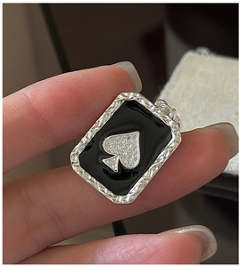 Macro view of S925 silver spade pendant featuring textured edges and black enamel inlay