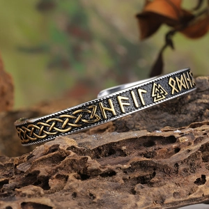 Detailed view of Viking cuff bracelet featuring golden runes on aged metal surface