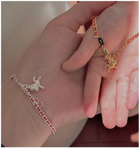 Dettaglio dei ciondoli a maialino in argento S925 su bracciali intrecciati rossi