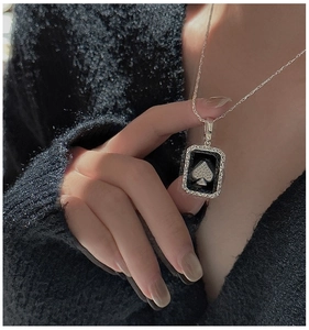 Close-up of S925 sterling silver necklace with a sparkling ace of spades rectangular pendant