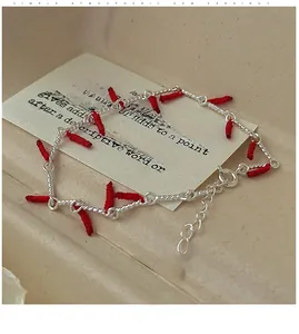 Close-up of S925 sterling silver chain with red woven silk and heart charm detail