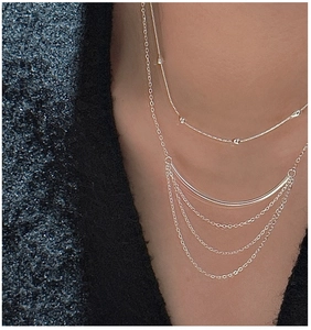 Close-up of S925 sterling silver multilayer fringe necklace on a tweed jacket
