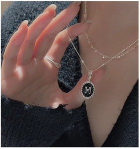 Dettaglio della collana in argento S925 con ciondolo a H nero e bordo a corda ritorta