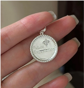 Detailed macro view of an S925 sterling silver star pendant with Future Expectation text