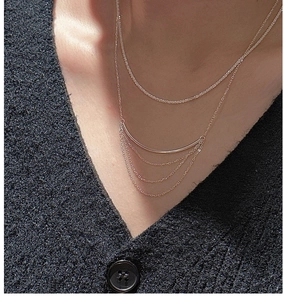 Detail view of layered rose gold fringe necklace with shimmering rhinestones and tassel