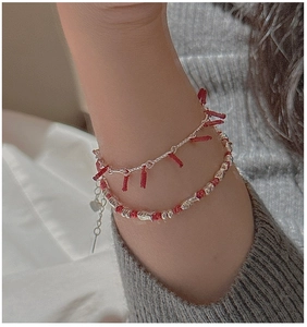 Detail of S925 silver firecracker bracelet with red tassels and small fish charm