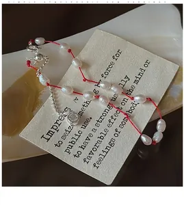 Détail d'un bracelet en cordon rouge avec perles d'eau douce baroques et pendentif zircon