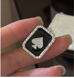 Macro shot of S925 silver spade pendant with black enamel and sparkling crystals