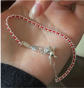 Dettaglio del ciondolo a cavallo in argento S925 e braccialetto intrecciato rosso con chiusura