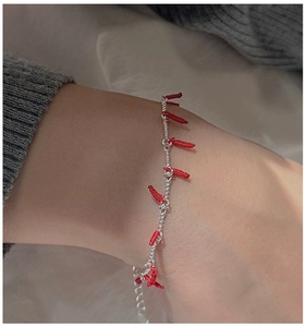 Detail of S925 silver bracelet with woven red chili charms on a person's wrist