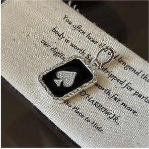Macro detail of S925 silver spade pendant with black enamel inlay and sparkling crystals