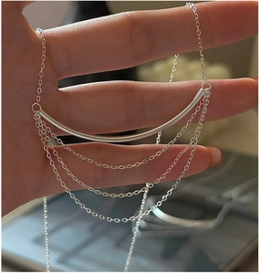 Detail of S925 sterling silver multilayer necklace featuring sleek curved tube and tassels