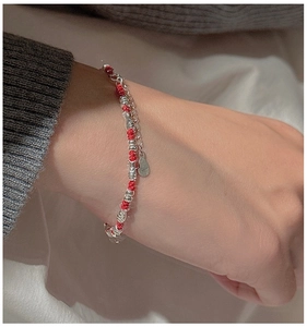 Close-up of S925 sterling silver beads and woven red string bracelet on wrist