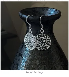 Detailed view of S925 sterling silver hollow round earrings with intricate filigree pattern