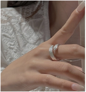 Detailed view of silver minimalist crossover ring with crushed ice texture on model hand