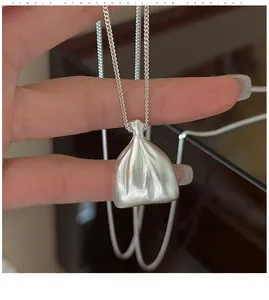 Vue macro du collier avec pendentif sac de fortune en argent mat et finition sablée