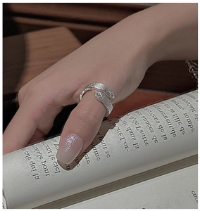 Detail of S925 sterling silver ring with hammer texture worn on hand while reading