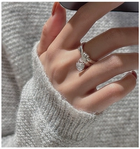 Close-up of S925 sterling silver twist ring with a heart-shaped zircon pendant on hand