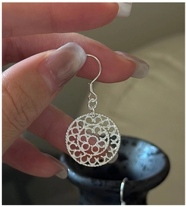 Macro view of S925 sterling silver drop earring with hollow mandala floral pattern