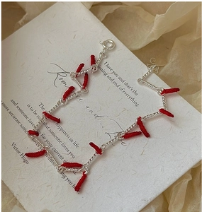 Detail of S925 silver bracelet featuring red thread accents and spring ring clasp