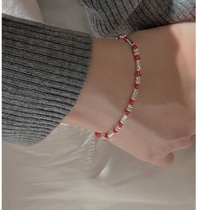 Detailaufnahme eines roten Kordelarmbands mit S925 Silber-Bambuselementen am Handgelenk