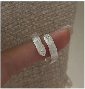 Detailed view of S925 silver ring with bark texture and small inset crystals on fingers