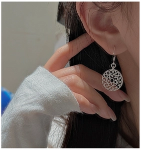 Close-up of S925 sterling silver drop earrings featuring hollow mandala flower design