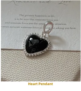 Detail of S925 silver heart pendant with black enamel inlay and beaded retro border