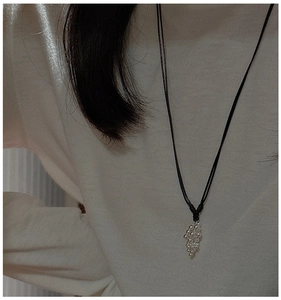 Detailed view of S925 silver grape cluster pendant on a black cord necklace