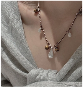 Close-up of S925 silver brushed teardrop pendants on a beaded tiger eye stone necklace