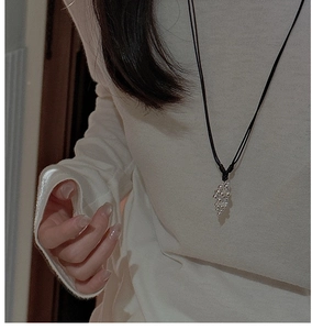 Detail of silver grape cluster pendant on a simple black cord necklace for women