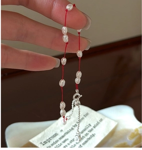 Détail du bracelet en cordon rouge avec perles baroques et fermoir mousqueton en argent S925