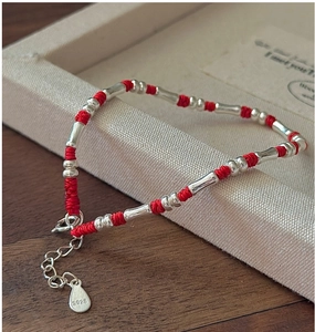 Makroaufnahme von S925 Sterlingsilber Bambusrohren und rotem geflochtenem Armband