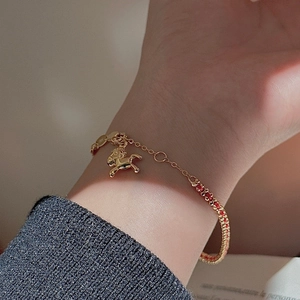 Elegante bracciale con ciondolo a forma di cavallo dorato e accenti rossi intrecciati