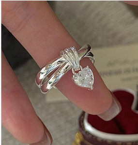 Macro shot of silver triple-layered interlocking ring with heart-shaped zircon charm