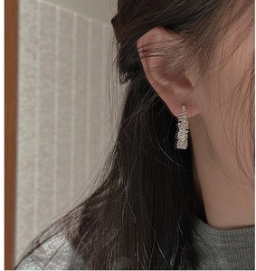Close-up of S925 sterling silver hoop earrings featuring a unique textured wrinkled design