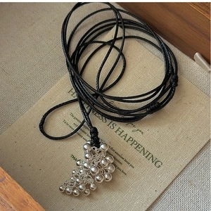 Detail of vintage S925 silver grape cluster pendant on a black cord necklace