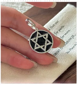 Macro shot of S925 sterling silver hexagram pendant with black enamel finish on linen