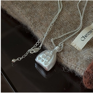 Détail du pendentif sac en argent S925 avec motif cœur mat et chaîne délicate en maille O