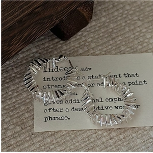 Close-up of S925 sterling silver earrings with textured geometric patterns and S925 hallmark