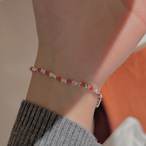 Red braided cord bracelet with S925 silver fish charm worn on wrist for Lunar New Year