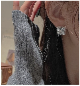 Detail of square silver studs with geometric texture shown on model for a modern look
