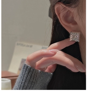 Close-up of geometric square S925 silver stud earrings with 3D rhombus pattern