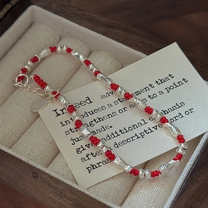S925 sterling silver red woven bracelet with fish charms on a vintage jewelry gift card