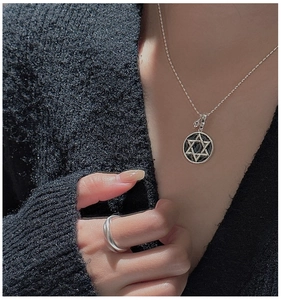 Detailed close-up of S925 sterling silver hexagram pendant and matching ring on model
